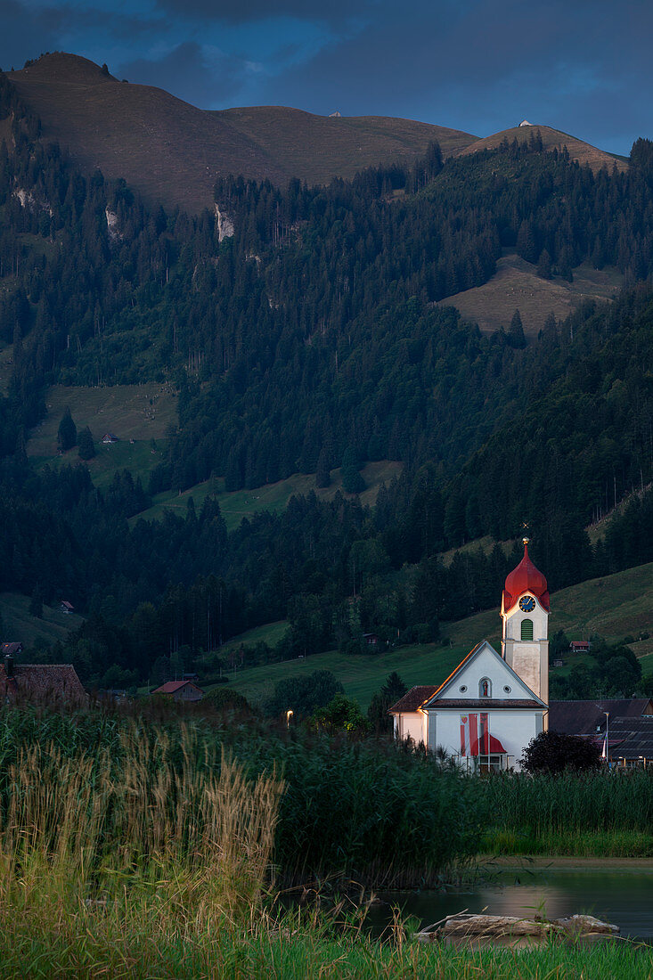 Church Euthal on Sihlsee with reeds and mountains, Einsiedeln Switzerland