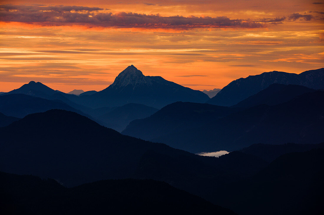 Mountain silhouettes of the Bavarian Prealps on Lake Walchensee in sunrise, from Jochberg