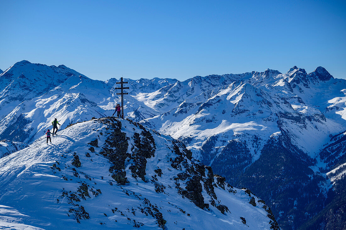 Mehrere Personen auf Skitour am Kreuz des Wetterkreuzkogel, Ötztaler Alpen im Hintergrund, Wetterkreuzkogel, Stubaier Alpen, Tirol, Österreich 
