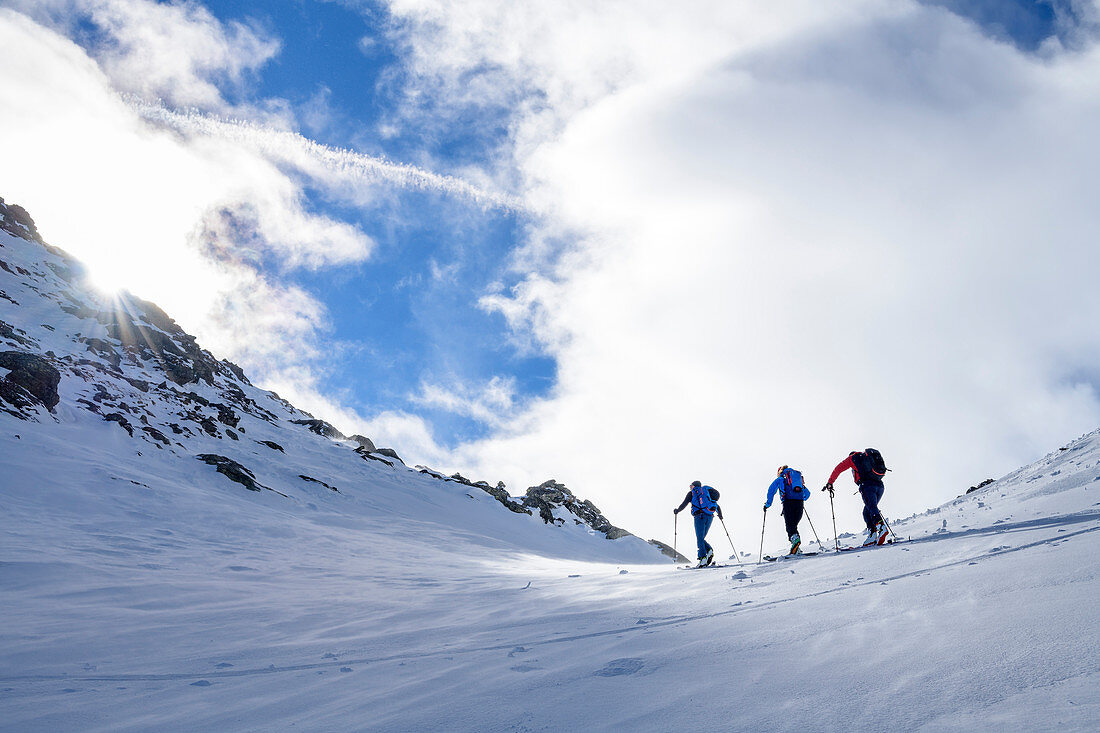 Drei Personen auf Skitour steigen durch Tal auf, Pangert, Tuxer Alpen, Tirol, Österreich