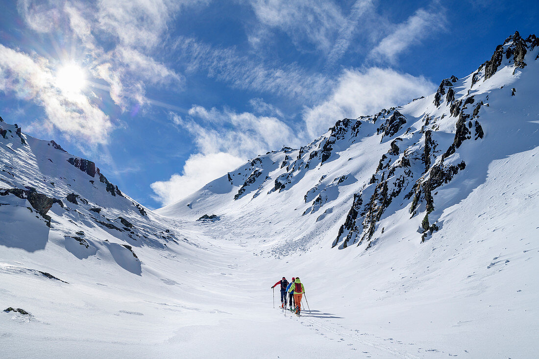 Three people on ski tour ascend through valley, Pangert, Tux Alps, Tyrol, Austria