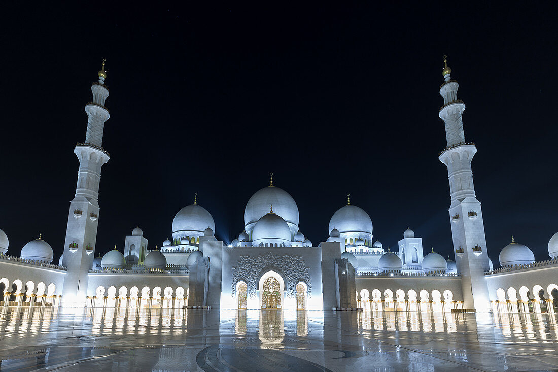 Front view of the illuminated Sheikh Zayid Mosque in Abu Dhabi, UAE
