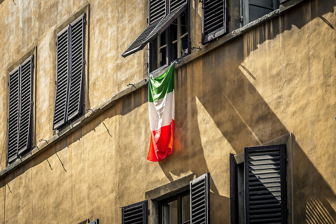 Häuserfassade mit italienischer Flagge in Florenz, Italien
