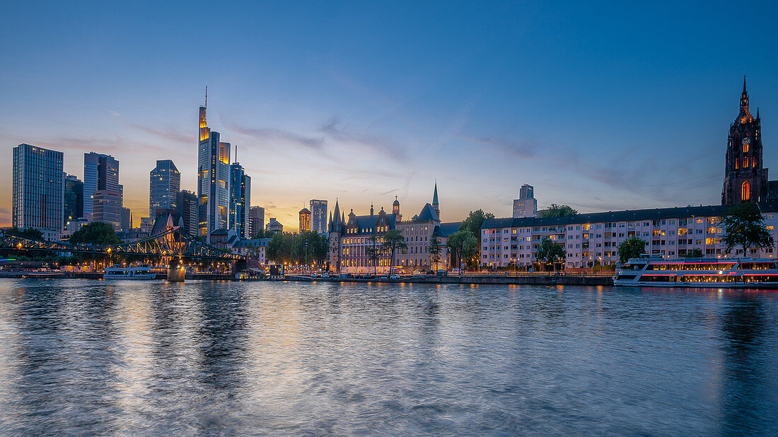 Blick auf den Eisernen Steg, das Bankenviertel und den Kaiserdom kurz nach Sonnenuntergang in Frankfurt am Main, Deutschland