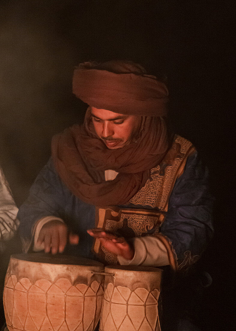Berber musiziert am Abend am Lagerfeuer in der Erg Chebbi, Sahara, Marokko