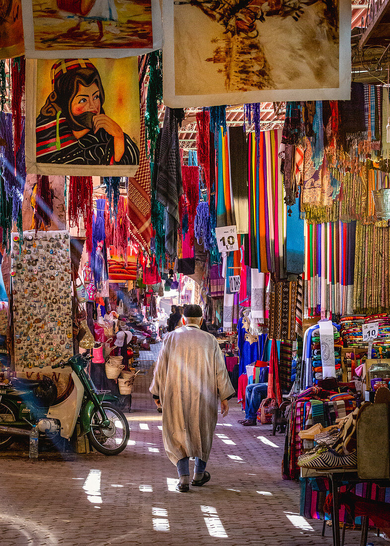 Elderly local man walks through the souk of Marrakech, Morocco