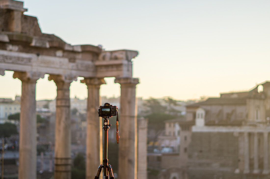 Camera photographs the Roman Forum during the sunrise in Rome, Italy