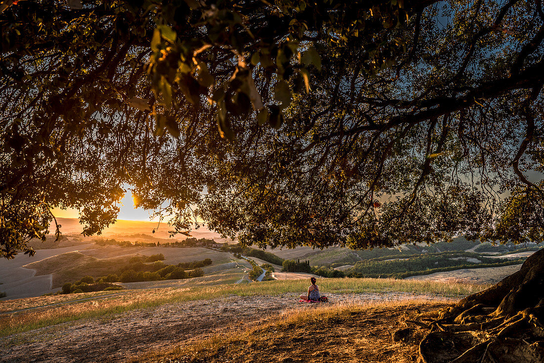 Junge Frau bei Meditation im Abendlicht, Buonconvento, Toskana, Italien