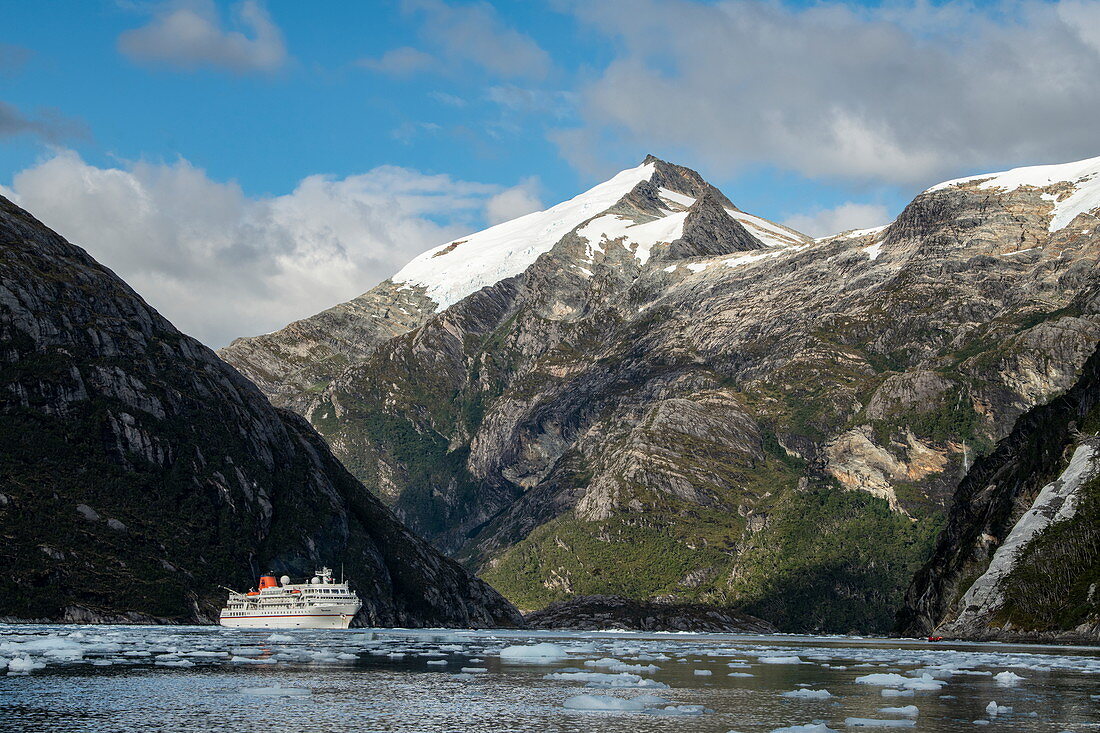 While the passengers enjoy the trip with a Zodiac rubber dinghy along the glacier, the expedition cruise ship MS Bremen (Hapag-Lloyd Cruises) is surrounded by mountains at anchor, Garibaldi glacier, near Beagle Canal, Alberto de Agostini National Park, Magallanes y de la Antartica Chilena, Patagonia, Chile, South America