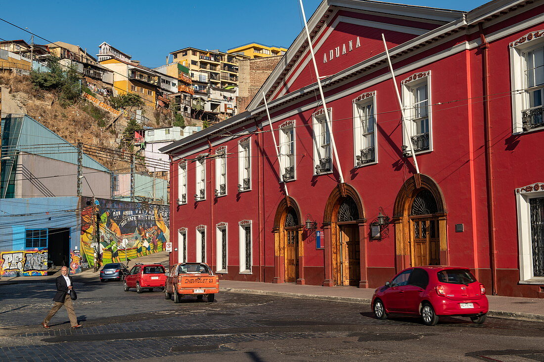 Das dunkelrote Zollgebäude befindet sich in der Nähe einer der vielen Standseilbahnen der hügeligen Stadt, Valparaiso, Valparaiso, Chile, Südamerika