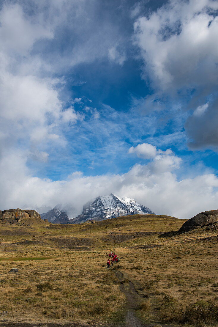 Dramatische Landschaft von sanften Hügeln, schneebedeckten Bergen und teilweise bewölktem Himmel, Nationalpark Torres del Paine, Magallanes y de la Antartica Chilena, Patagonien, Chile, Südamerika