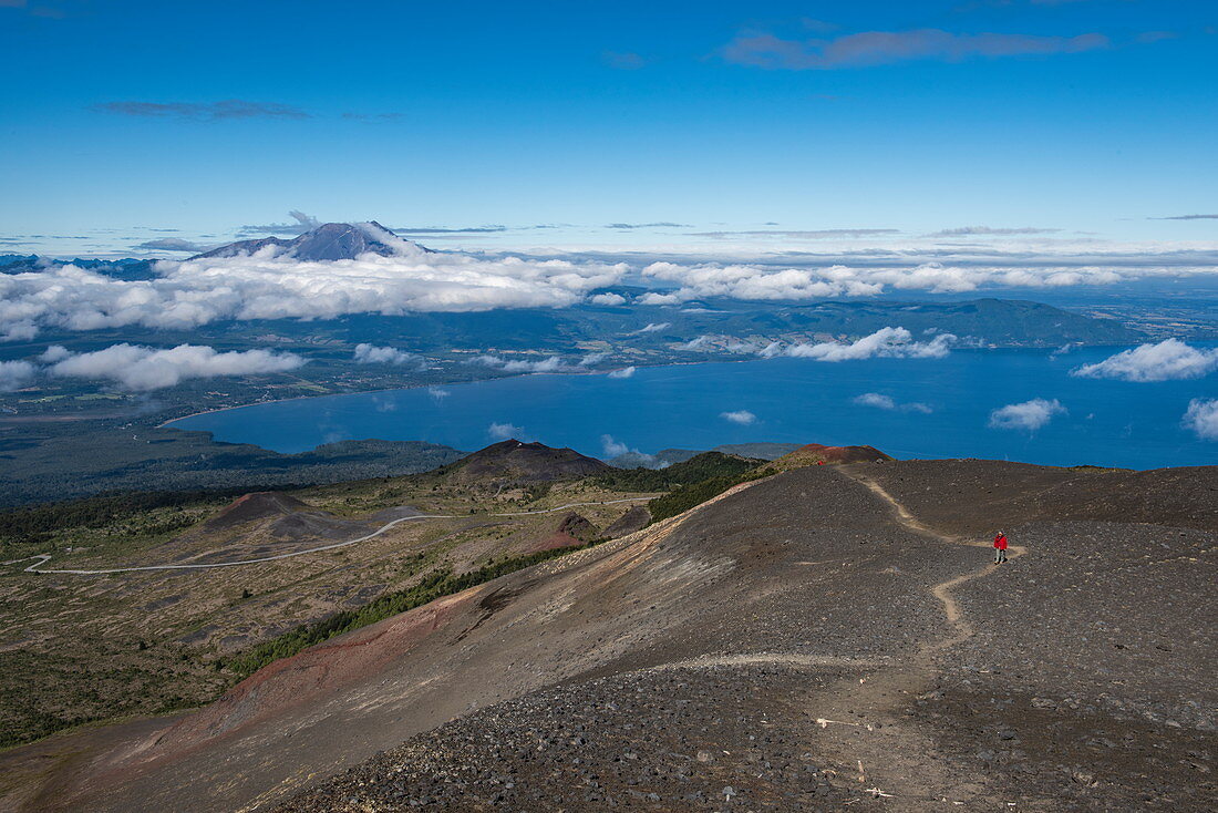 Visitors follow the path through barren lava fields on the slopes of the majestic volcano Osorno on Lake Llanquihue, near Puerto Montt, Los Lagos, Patagonia, Chile, South America