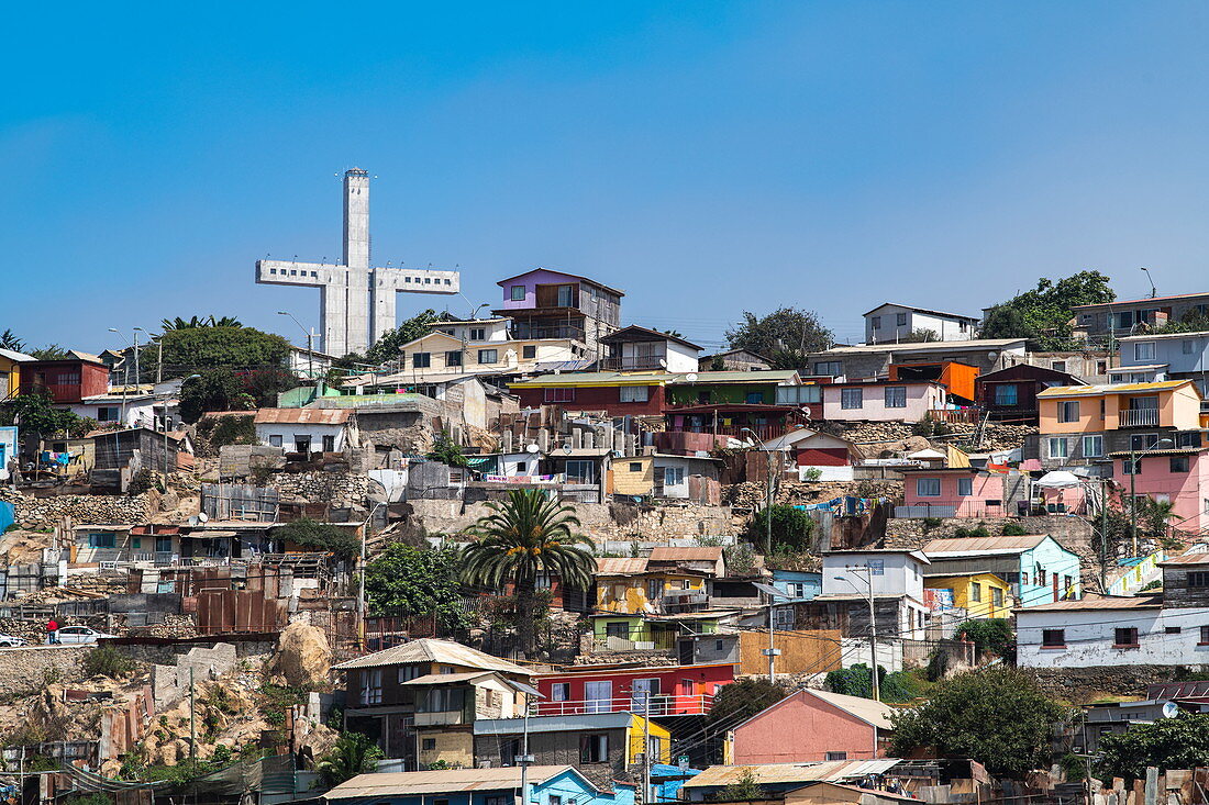 Dicht aneinanderstehende, farbenfrohe Häuser am Hang mit einem monumentalen Kreuz, La Serena, Coquimbo, Chile, Südamerika