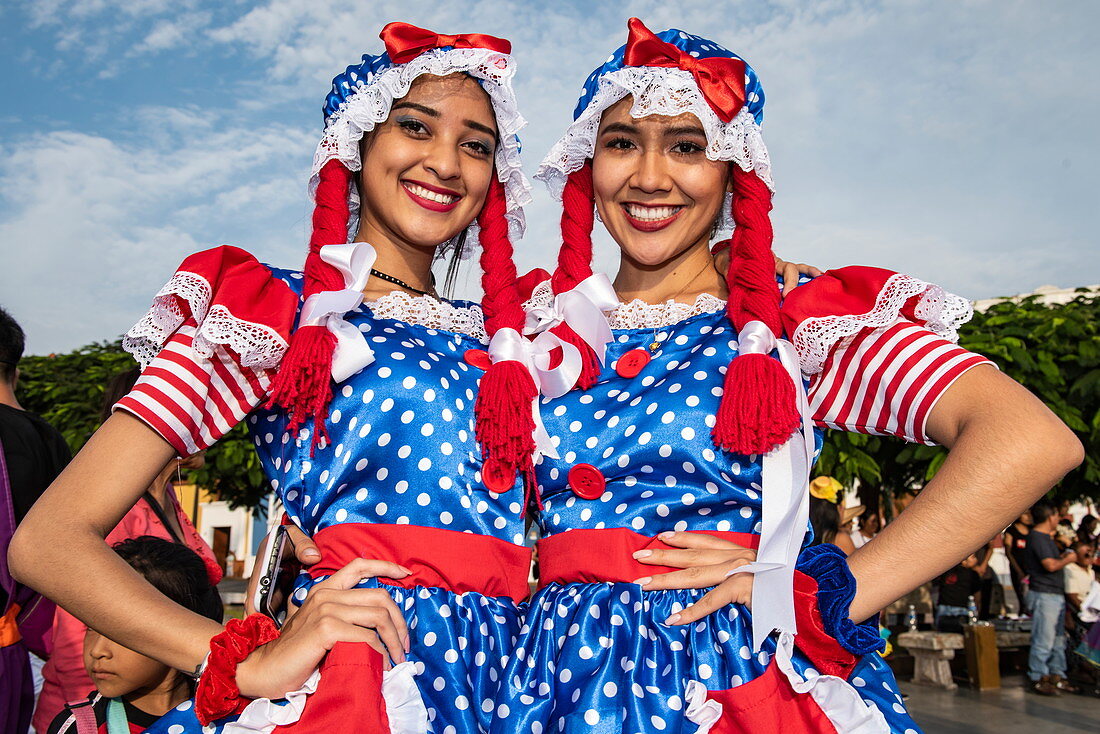 Zwei schöne junge Frauen in buntem Kostüm pausieren von Feiern an der Plaza de Armas, Trujillo, La Libertad, Peru, Südamerika