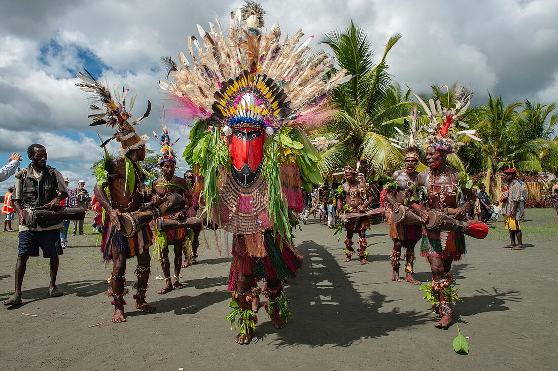 Männer in farbenfrohen Kostümen führen einen Folkloretanz auf zur Begrüßung von Passagieren eines Expeditionskreuzfahrtschiffes, Kopar, Provinz Ost-Sepik, Papua-Neuguinea, Südpazifik