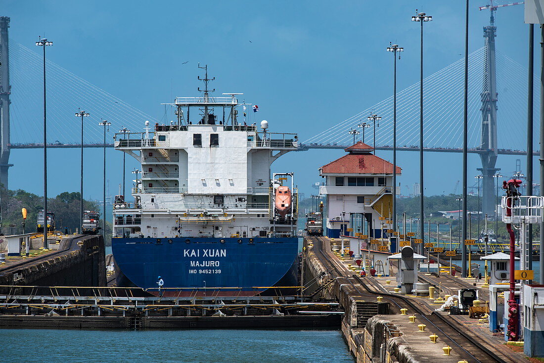 Ein Frachtschiff in den Gatun-Schleusen im Panamakanal, Atlantikbrücke im Hintergrund, nahe Panama City, Panama, Mittelamerika
