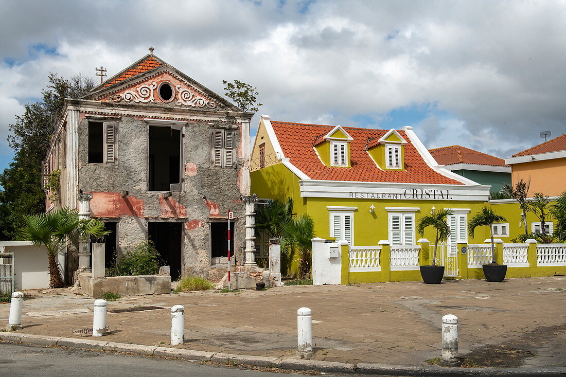 A derelict, derelict building contrasts with its bright, recently restored neighbor on the right, Willemstad, Curacao, Netherlands Antilles, Caribbean