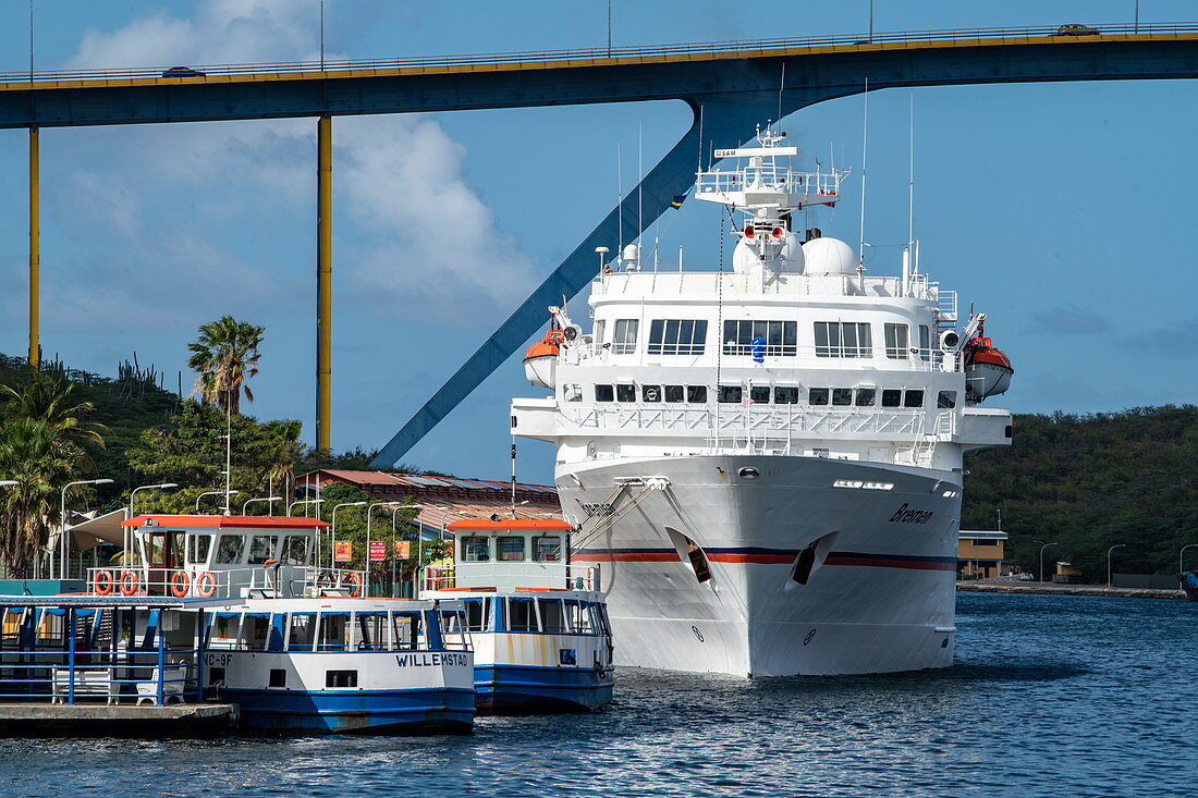 The expedition cruise ship MS Bremen (Hapag-Lloyd Cruises) outshines other boats on the pier, Willemstad, Curaçao, Netherlands Antilles, Caribbean