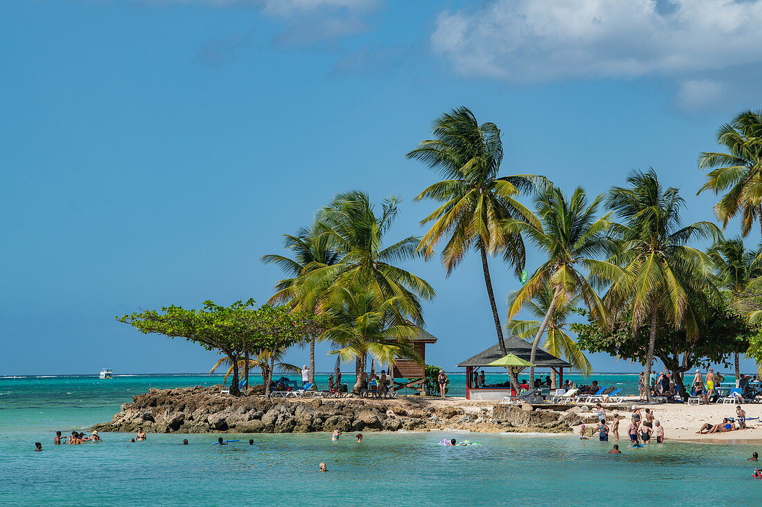 Eine mit Palmen bewachsene, steinige Landzunge mit Touristen, Pigeon Point, Tobago, Trinidad und Tobago, Karibik