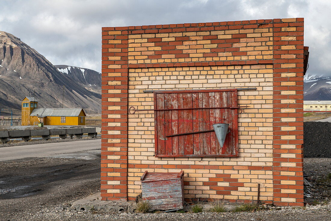 An unused building stands opposite the runway for the former mining town of Pyramiden, Billefjord, Spitsbergen, Norway, Europe