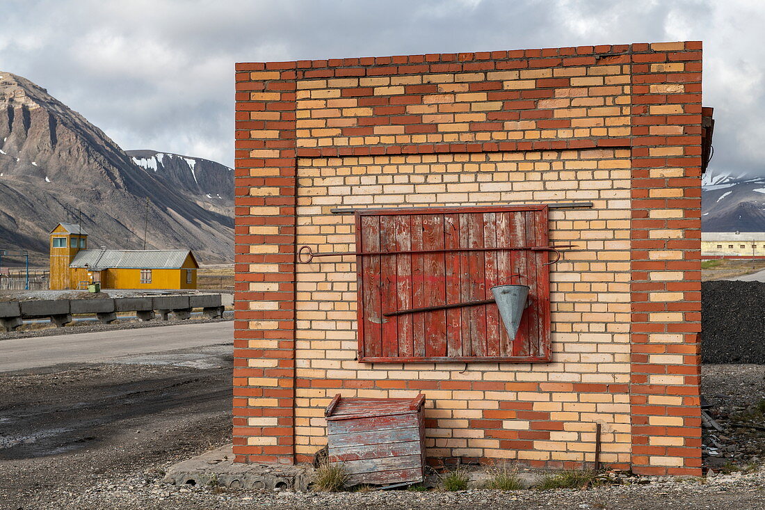 Ein ungenutztes Gebäude steht gegenüber der Landebahn für die ehemalige Bergbaustadt Pyramiden, Billefjord, Spitzbergen, Norwegen, Europa