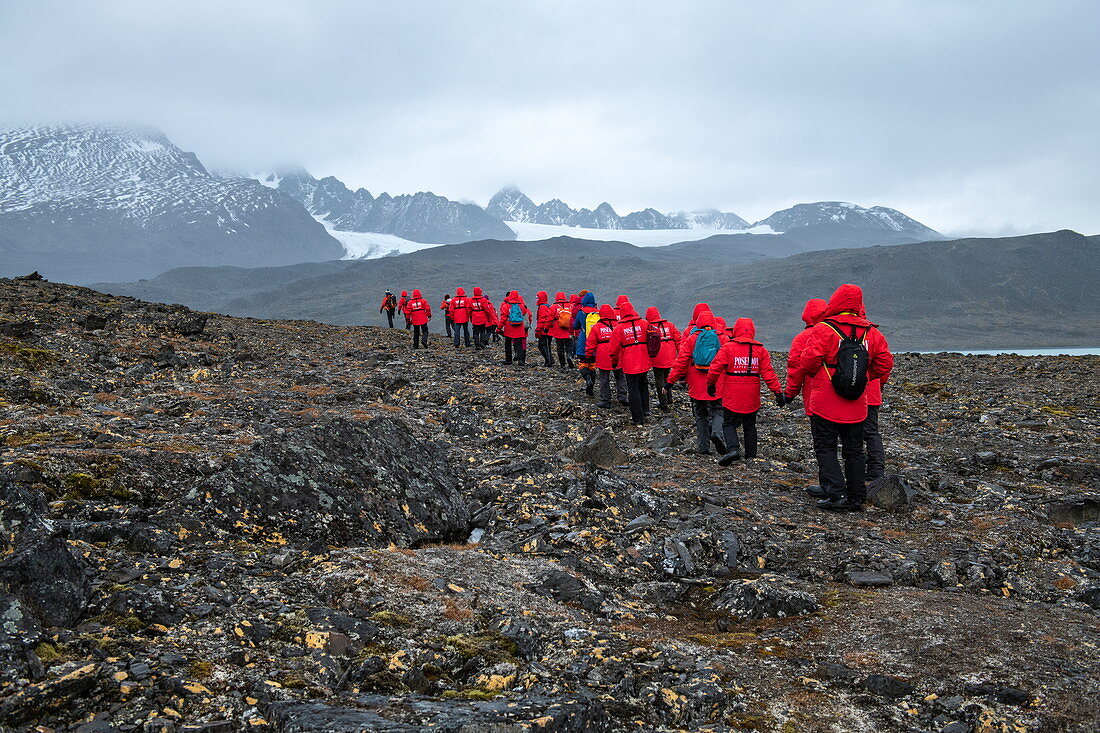 Passengers on the expedition cruise ship MS Sea Spirit (Poseidon Expeditions) begin a hike across rocky ground, Signehamna, Albert I Land, Svalbard, Norway, Europe