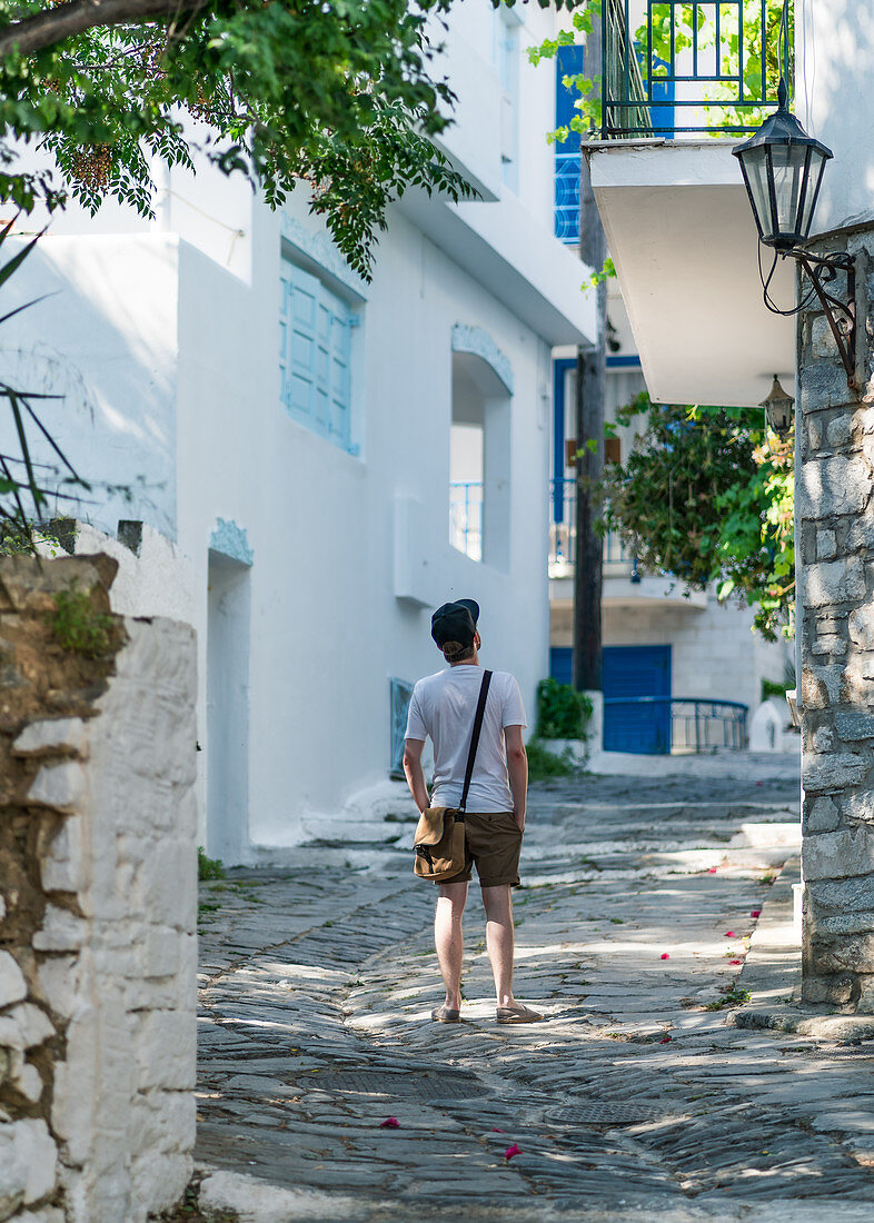 Tourist explores the alleys of Skiathos, Greece