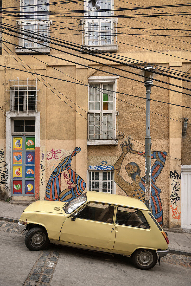 Streetart und altes Auto an einer steilen Straße in Valparaiso, Chile, Südamerika