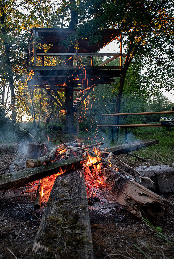 Ein Lagerfeuer bei einem Baumhaus, München, Bayern, Deutschland, Europa