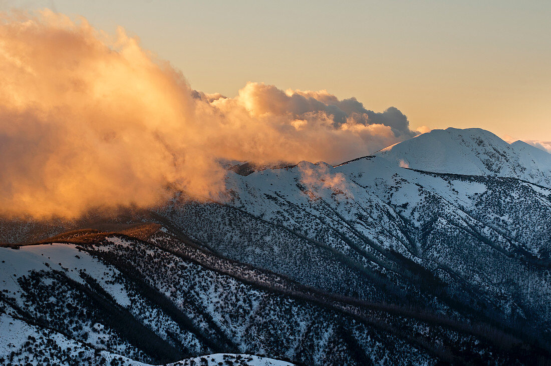 Spätes Licht lässt die Wolken an der Razorback Ridge am Mount Feathertop im Alpine National Park aufglühen, Victoria, Australien