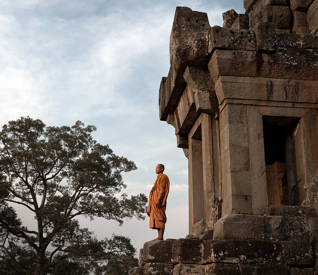 Siem Reap, Cambodia - January 19, 2011: A monk is standing on a platform in Ta Keo, which is part of Angkor.
