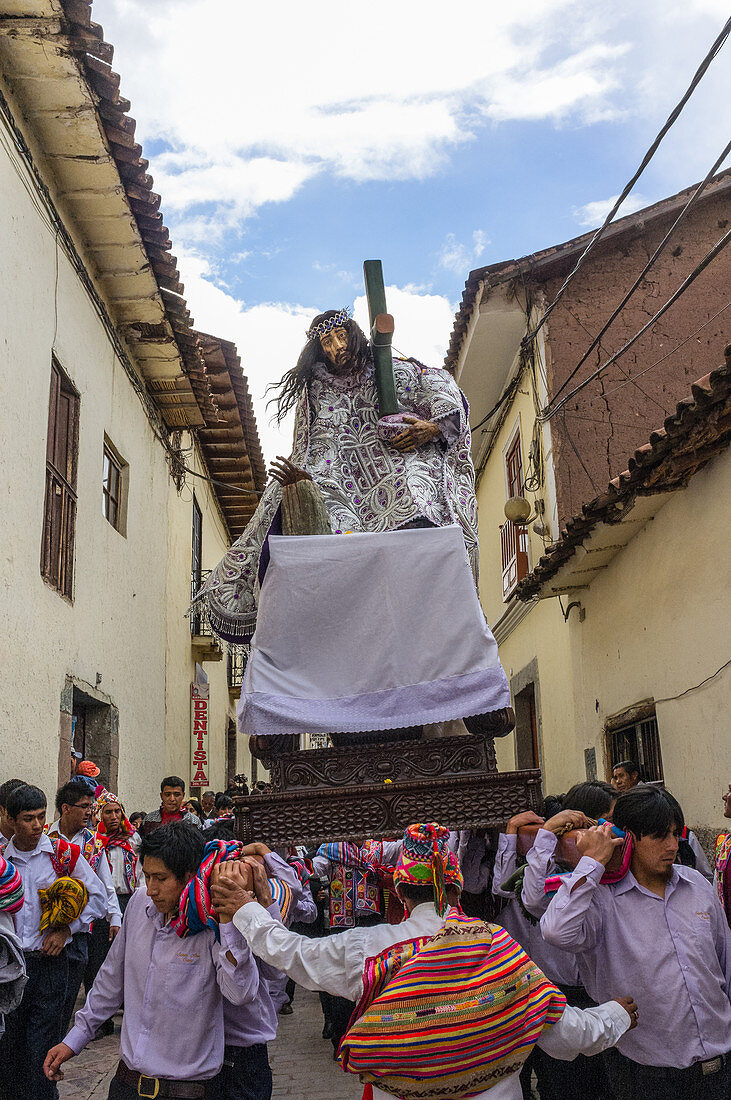 Cusco, Peru - 2. Januar 2012: Eine Gruppe von Männern trägt eine Sänfte mit einer Jesus-Statue auf einem Straßenfest