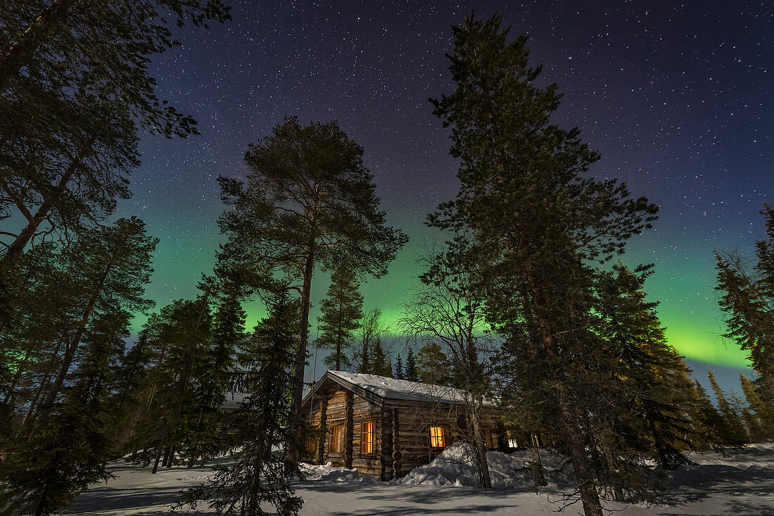 Gemütliche Blockhütte unter Nordlicht, Luosto, Finnland