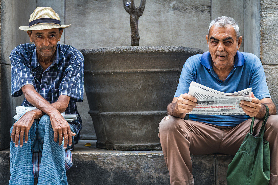 Two Cubans sit on the side of the road, Havana, Cuba