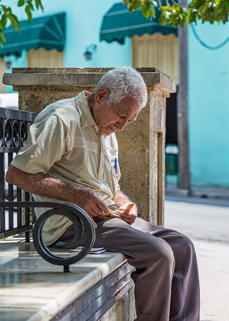 Älterer kubanischer Mann sitzt auf einer Parkbank, Camagüey, Kuba
