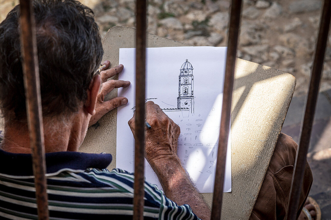 Artist draws bell tower in Trinidad, Cuba