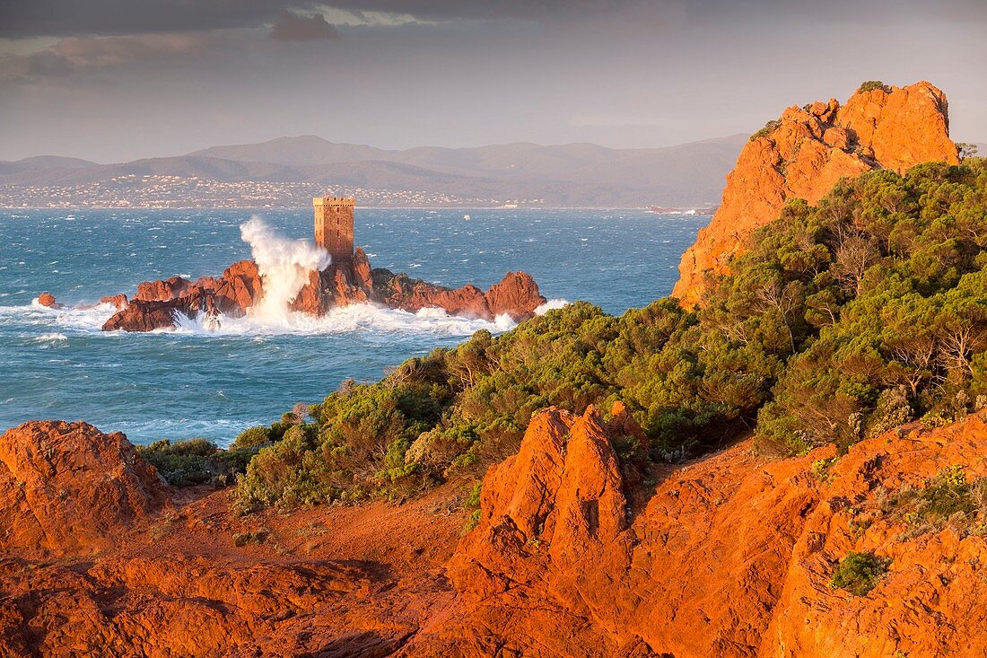 Frankreich, Var, Saint-Raphaël, starker Wellengang und starker Wind auf den roten Klippen vulkanischen Ursprungs (Rhyolith) des Cap du Dramont, im Hintergrund der Turm der Ile d'Or