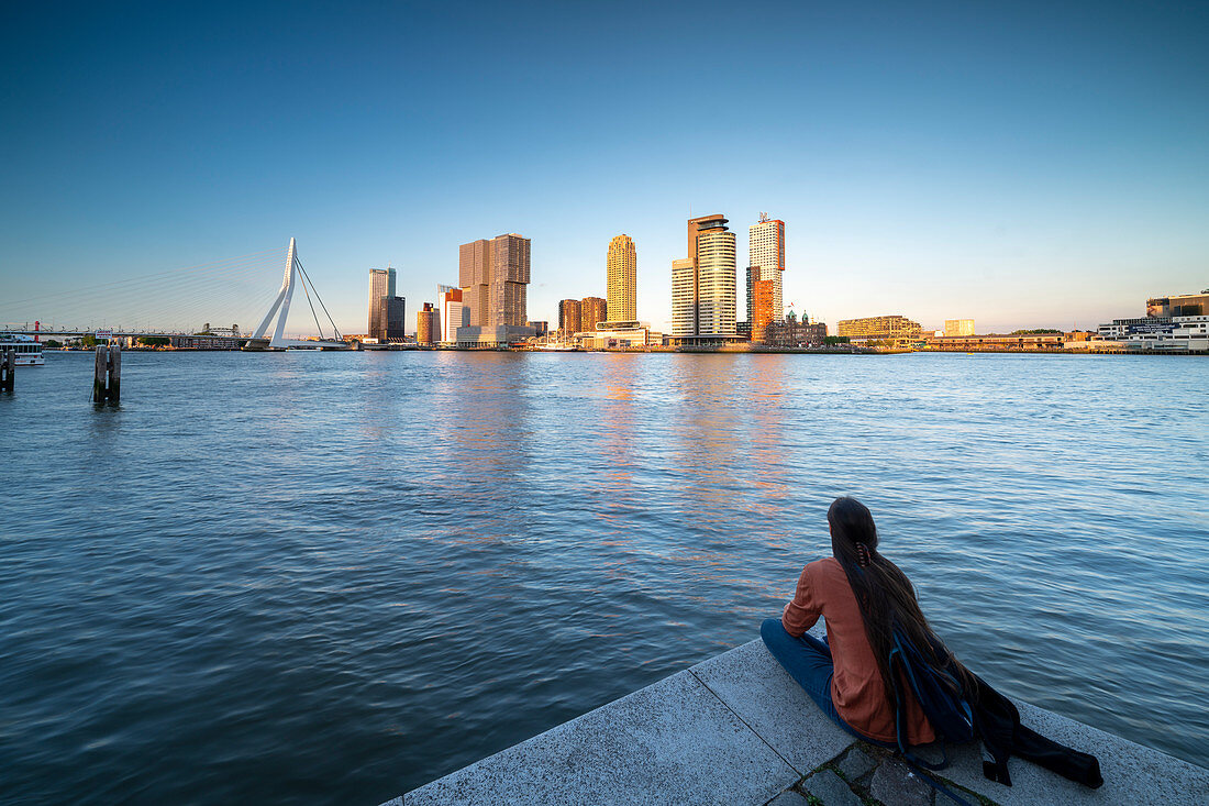 Abendlicher Blick über die Neue Maas auf die Erasmusbrücke und die Skyline am Cruise Terminal in Rotterdam, Niederlande