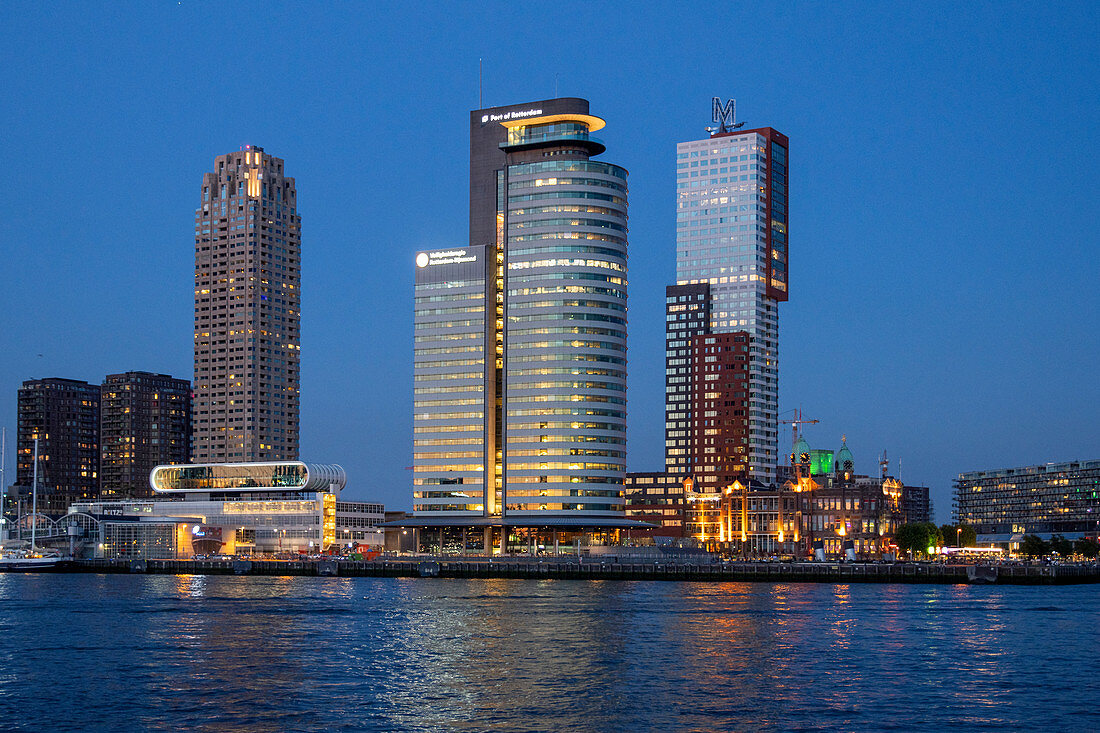 Blick während der Blauen Stunde über die Neue Maas auf die Erasmusbrücke und die Skyline am Cruise Terminal in Rotterdam, Niederlande