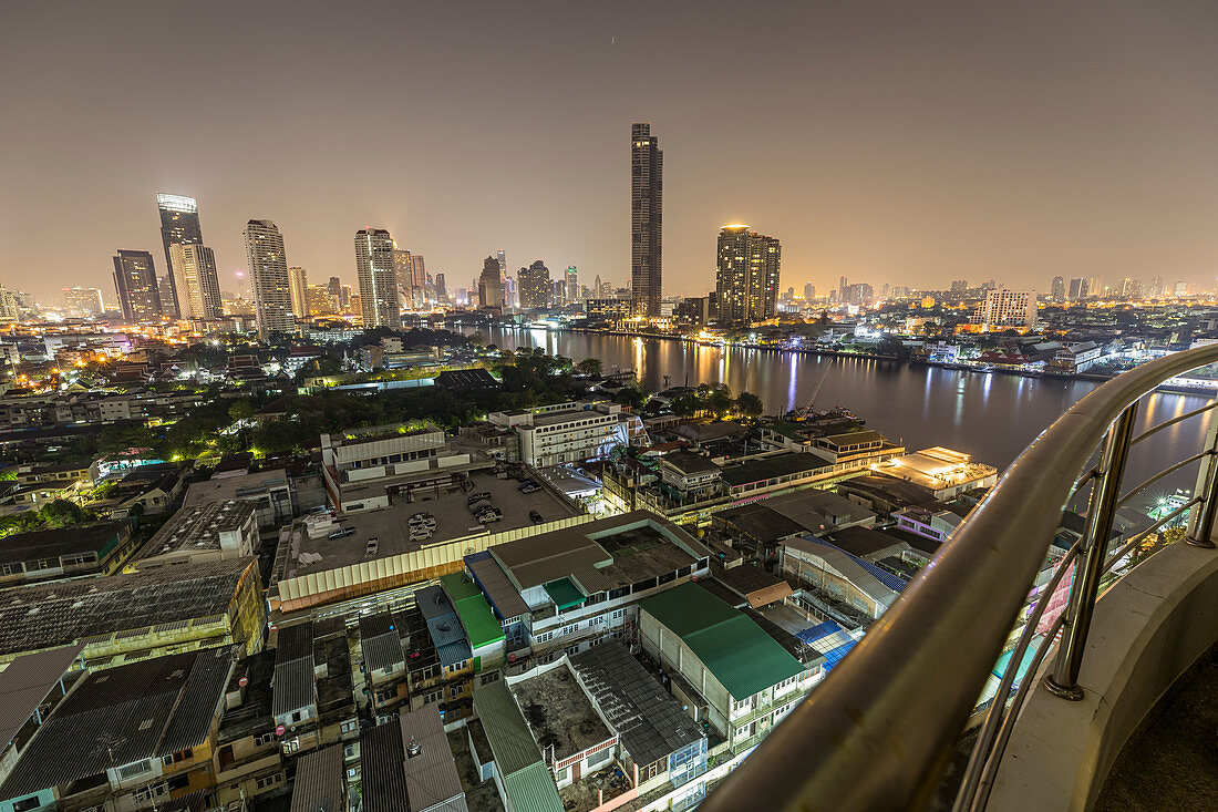 Blick auf den Chao Phraya River und die Skyline vom Supalai River Place bei Nacht, Bangkok, Thailand