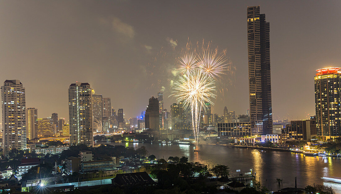 View of the Chao Phraya River and skyline with fireworks, view from Supalai River Place at night, Bangkok, Thailand