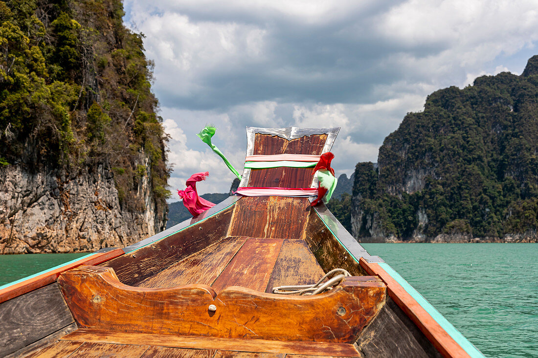 Fahrt mit Longtailboot auf dem Ratchaprapha See mit hohen Karstfelsen im Khao Sok Nationalpark, Khao Sok, Thailand