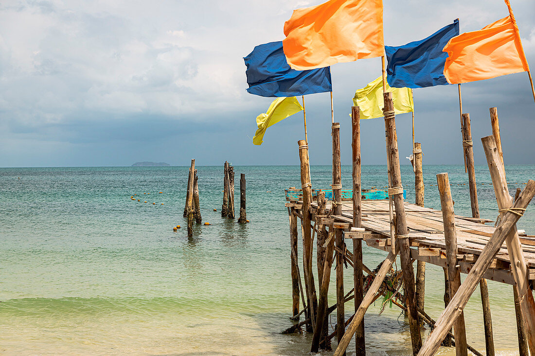 Jetty with colorful flags on Ao Wai beach, Koh Samet, Thailand
