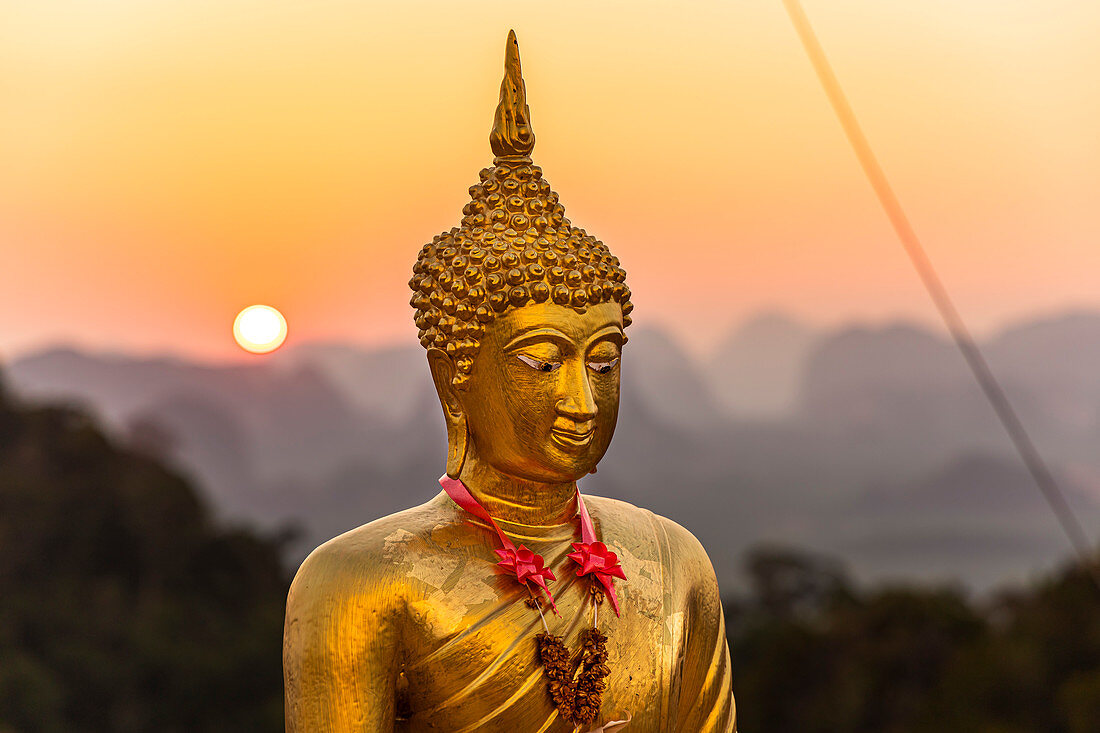 Buddha statue at sunset on Tiger Cave Mountain, Tiger Cave Temple, Krabi Town, Thailand