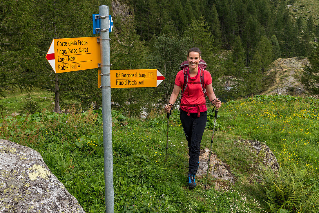 Wanderin an Wegweiser im Valle di Peccia, Trekking del Laghetti Alpini, Tessin, Schweiz