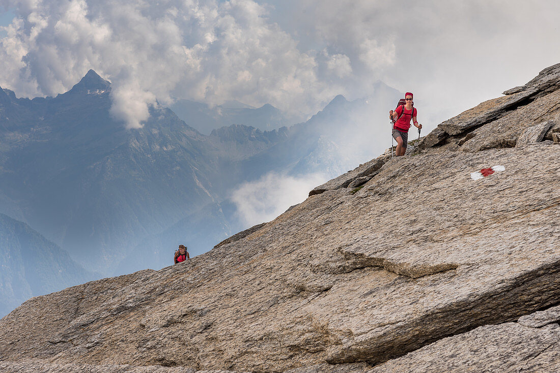 Female hikers climb to the Bochette de la Froda, Trekking del Laghetti Alpini, Ticino, Switzerland