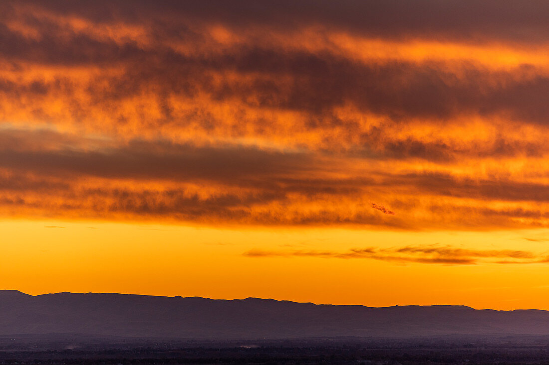 Silhouette vom Hügel unter dramatischem Himmel bei Sonnenuntergang