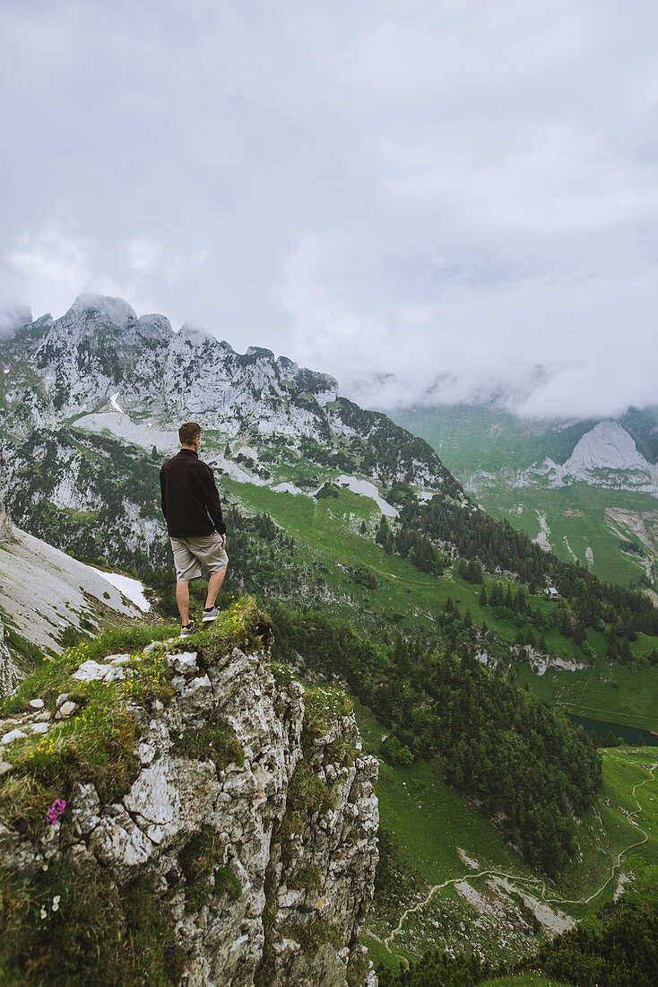 Man on rock by mountains