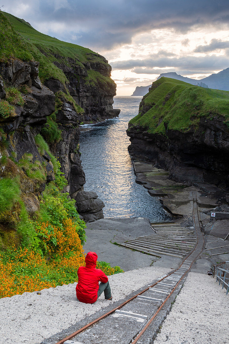 Man is admiring the sunrise in Gjogv, Eysturoy island, Faroe Islands, Denmark, Europe