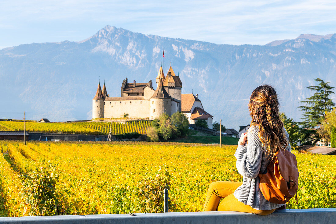 A young woman admires the Aigle Castle, Aigle, Canton of Vaud, Switzerland